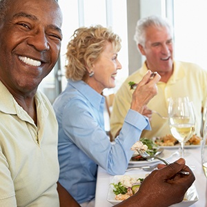 Patient in Richardson smiling with friends after getting dentures