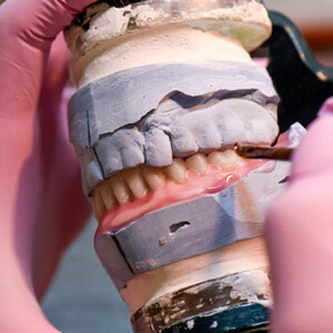 a technician working on constructing dentures 