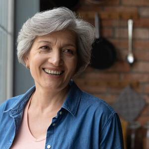 an older woman smiling with new dentures 