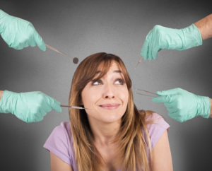 Woman looking nervously at several different dental tools